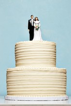 White Wedding Cake Topped With Bride And Groom Figurines