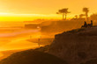 People enjoying the view of a stunningly colorful sunset in Santa Cruz, California in winter