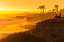 People Enjoying The View Of A Stunningly Colorful Sunset In Santa Cruz, California In Winter
