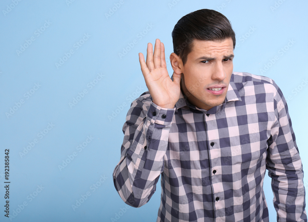 Man with hearing problem on color background