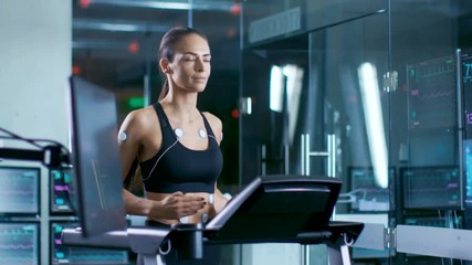 Wall Mural - in scientific sports laboratory beautiful woman athlete runs on a treadmill with electrodes attached