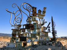 Collection Of Many Stacked Wooden Birdhouses Abandoned In Desert