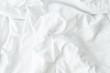 White wrinkled fabic texture,Close up unmade bed sheet in the bedroom after night sleep Soft focus