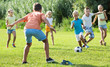 © JackF - Group of friendly kids playing football together on green lawn in park