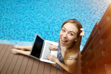 Wall Mural - Portrait of happy woman And laptop. Girl looking at camera happy, concept of new technologies, computer use remotely In summer sunny day