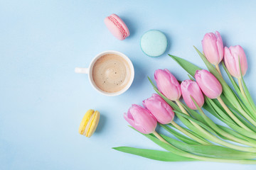 Wall Mural - Spring tulip flowers, colorful macaroons and coffee on blue pastel table top view. Beautiful breakfast on Mothers or Womans day. Flat lay.