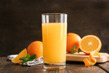 Glass of fresh orange juice on wooden table