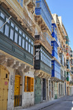 Fototapeta Na drzwi - a narrow street with picturesque and colorful tenement houses in Malta