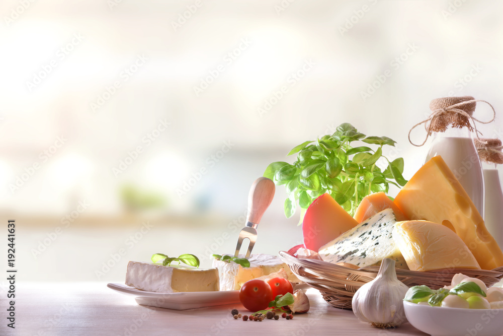 Cheeses presented on white wooden table in kitchen front view Stock ...