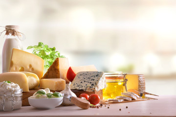 Cheeses presented on wooden table in kitchen front view