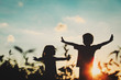 © nadezhda1906 - little boy and girl silhouettes play at sunset