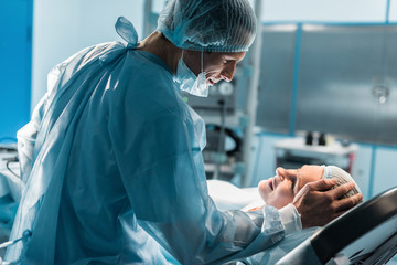 smiling doctor palming patient in surgery room