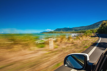 Wall Mural - road trip with motion blur along ellis beach near palm cove and cairns, australia