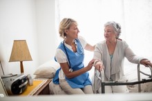 Nurse Helping Senior Woman To Stand Up