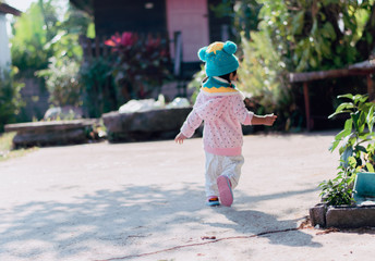 back view child running in garden on sunny winter day