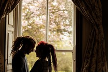 Romantic Young Couple Standing By Window