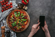 © LIGHTFIELD STUDIOS - cropped shot of woman using smartphone on concrete table with pizza