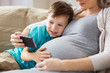 © Syda Productions - pregnant mother and son with smartphone at home
