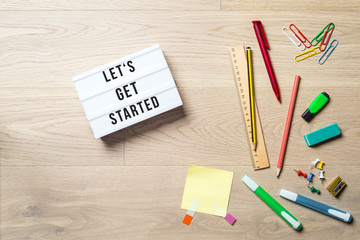 Wall Mural - Let's get started written on lightbox in office as flatlay