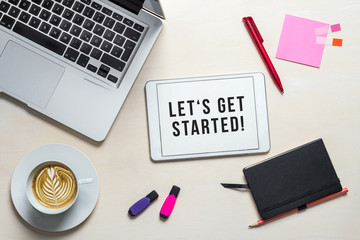 let's get started written on tablet lying on desk as flatlay