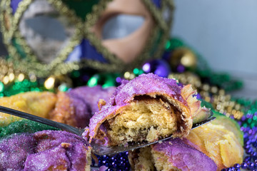 Wall Mural - Mardi Gras celebration with king cake slice, hanging beads, and mask