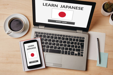 Wall Mural - learn japanese concept on laptop and smartphone screen over wooden table. all screen content is desi