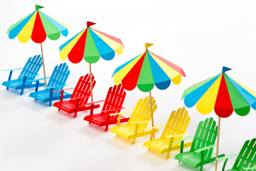 Wall Mural - Bright umbrellas folding chairs are made of paper on a white background