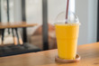 Sweet yellow mango smoothie on wood table in coffee shop
