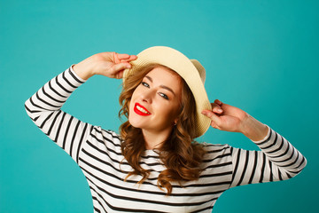 Wall Mural - Portrait of young beautiful smiley blond woman in hat over blue background