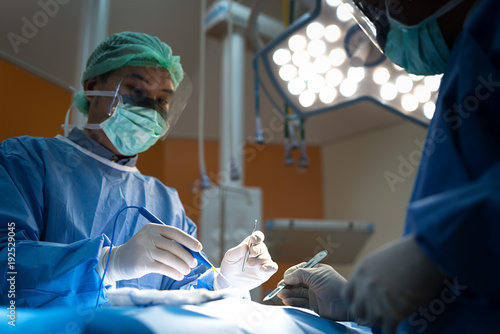 Plakat Azjatycki lekarz i asystent na sali operacyjnej w klinice chirurgii żylnej chirurgii naczyniowej w szpitalu.