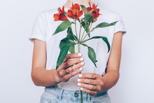 Girl In Jeans And A T-shirt Holding A Red Flower