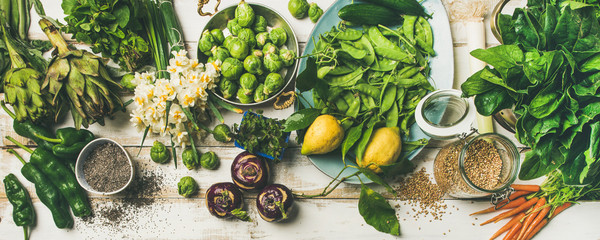 spring healthy vegan food cooking ingredients. flat-lay of vegetables, fruit, seeds, sprouts, flower