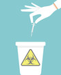 Hand throwing away used hypodermic needle into a trash bin with biohazard sign on it