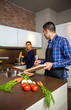 © David Pereiras - Young couple cutting vegetables in the kitchen to prepare food