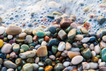 multi-colored pebbles on the beach, washed by waves