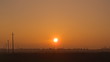 © Михаил  - the setting sun over the roofs of houses. a haze over the field. natural background.