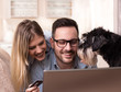 Young couple with dog shopping online at home