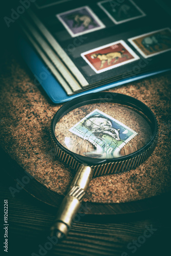 Stampe Book with postage stamps and a magnifying glass. Vintage style.