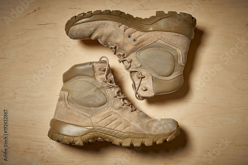 Papel de parede Top view of used military boots on a wooden background