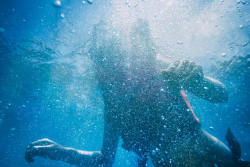  The silhouette of an attractive slim woman under water. The beauty of the ocean world. Ideal background for the different kinds of marine collages and illustrations in blue shades.