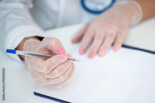 Рука В Медицинской Перчатке Держит Ручку, Заполняет Бланк Или.