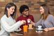 © Marko - Group of friends sitting at cafe while two are flirting