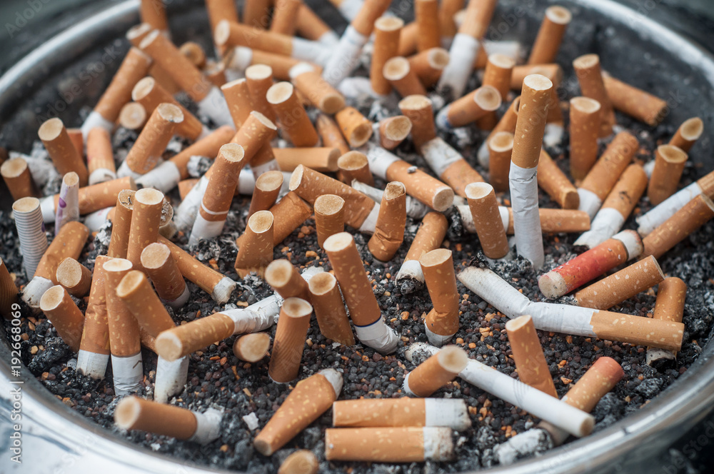 cigarettes dans un cendrier public plein Stock Photo