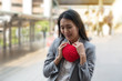 © kaew6566 - Young woman holding red heart shape on the stairs.waiting for Valentine's Day. woman's love and feelings.