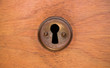 Old rusty and dusty keyhole wallpaper. Vintage keyhole on old wooden door background. Keyhole of old door.