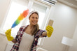 Young woman with gloves and colorful duster making selfie