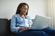 © Flamingo Images - Young African woman relaxing at home using a laptop