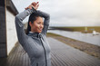 © Flamingo Images - Smiling young Asian woman warming up before a run