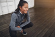 © Flamingo Images - Smiling Asian woman crouching on the ground outdoors before jogg