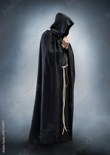 Cuadros en Lienzo Silhouette of a praying monk, folded hands in prayer